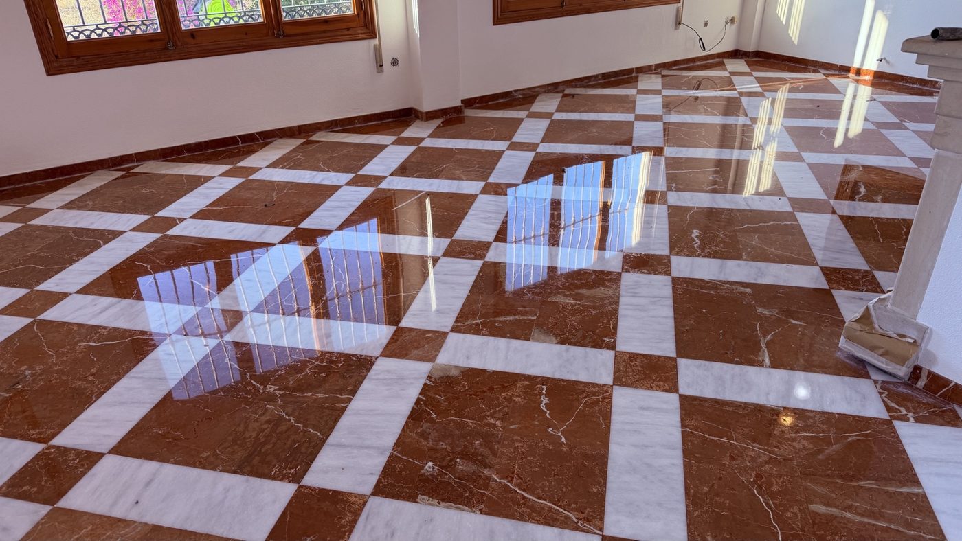 Suelo de mármol rojo y blanco con reflejos tras el trabajo