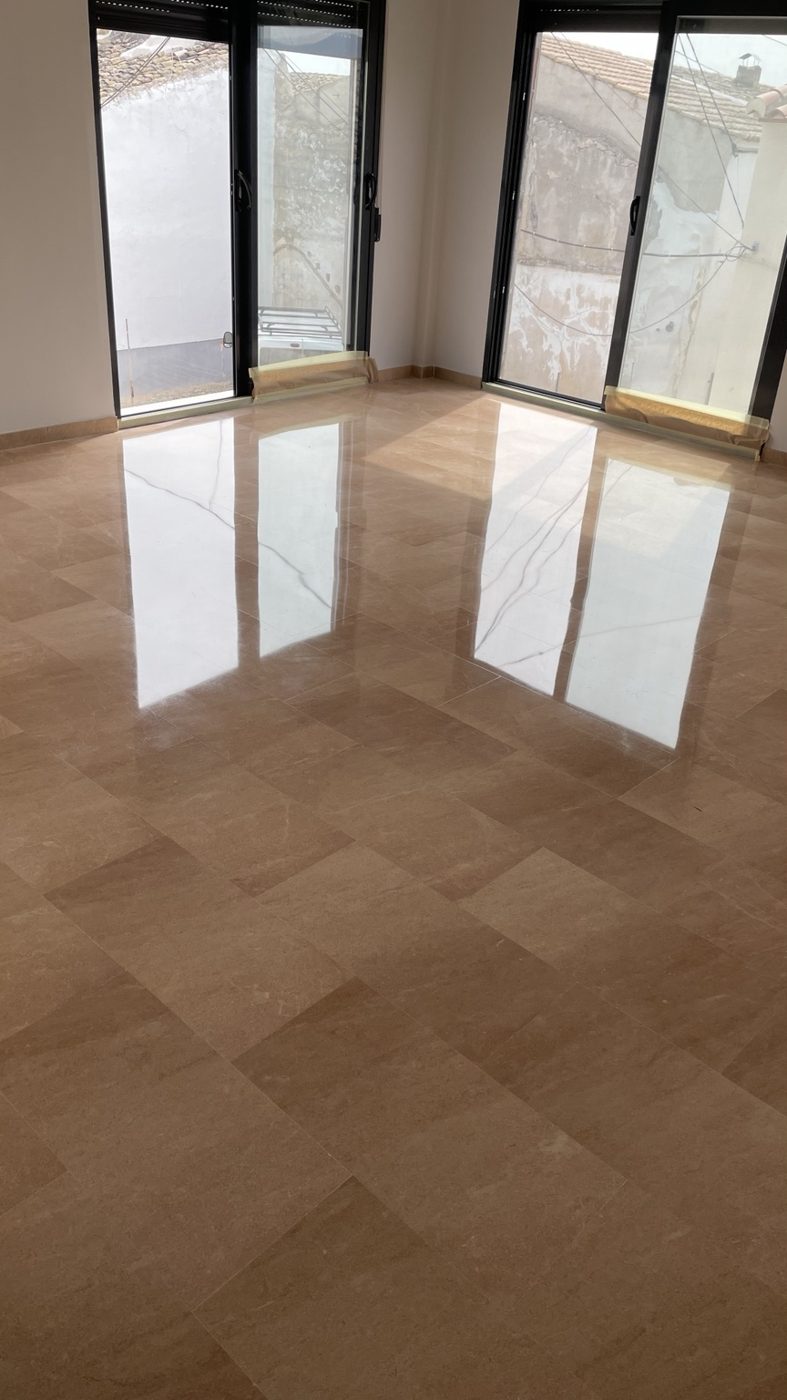 Suelo de mármol beige con reflejo de los ventanales